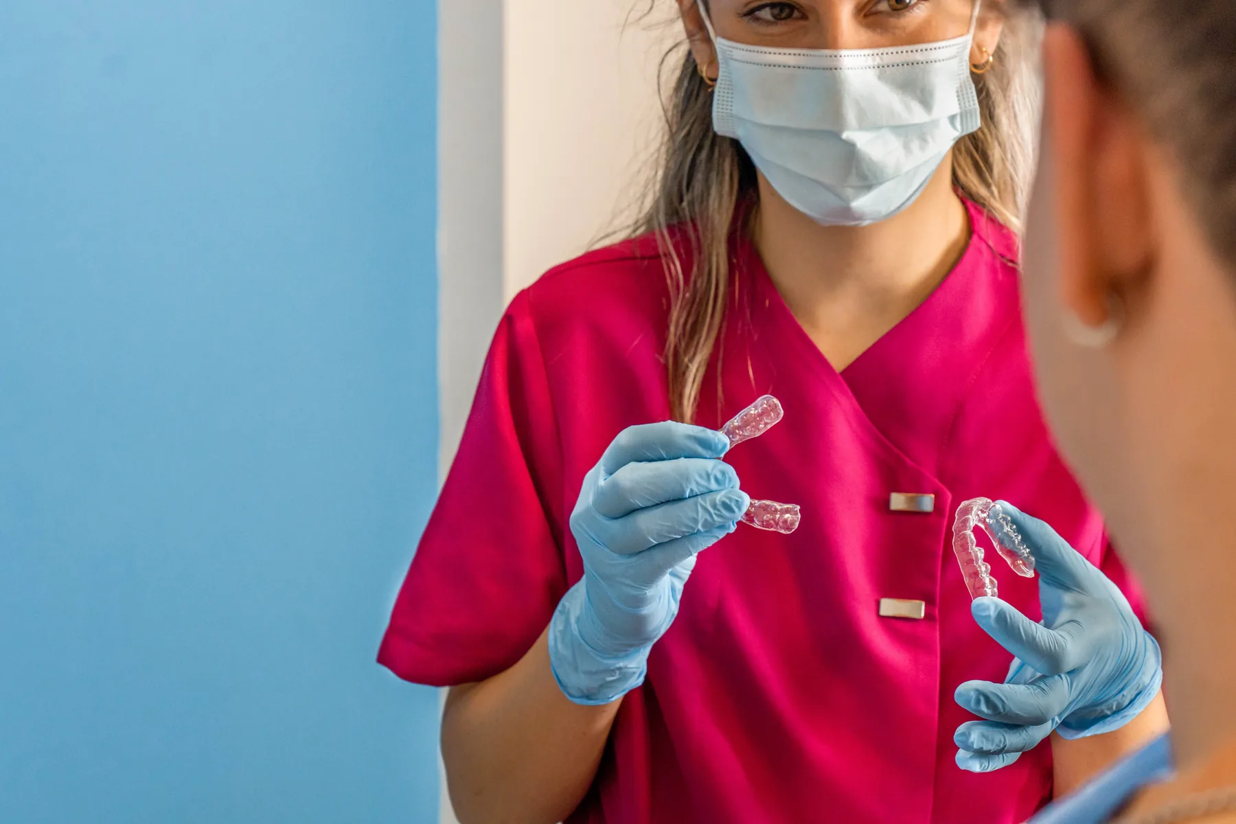 Dentist showing clear aligners to an adult orthodontic patient
