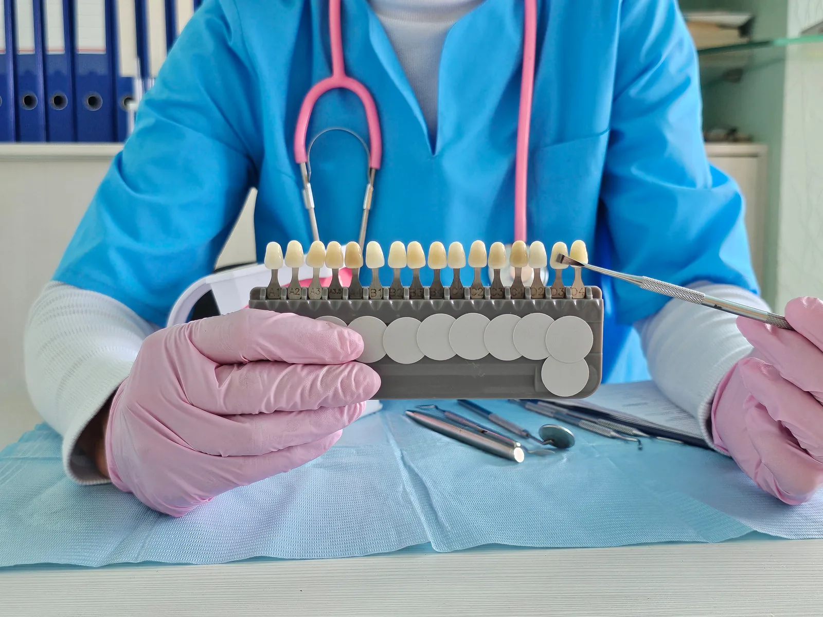 Dental professional reviewing a veneer shade guide during consultation