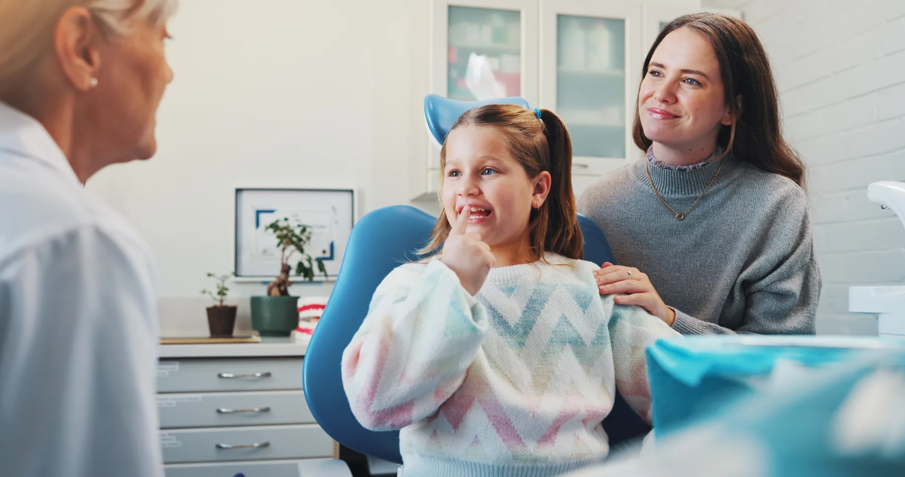 Family dentist discussing oral health with a child and parent during a consultation