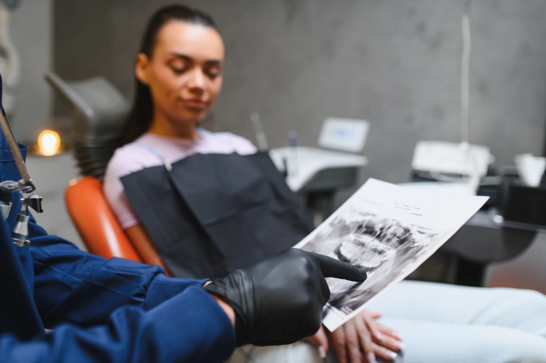 Dentist reviewing a panoramic dental X-ray with a patient during a comprehensive examination