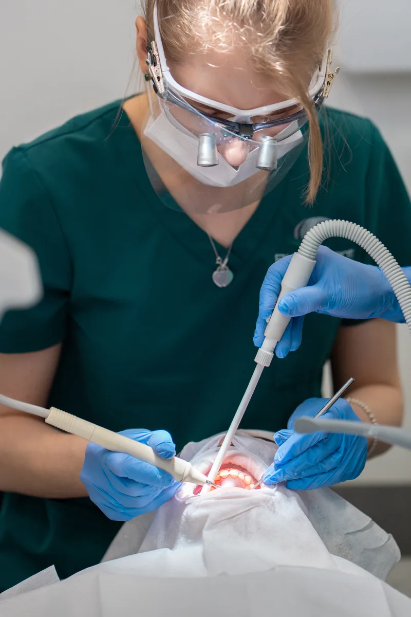 Dental hygienist performing ultrasonic scaling and polishing