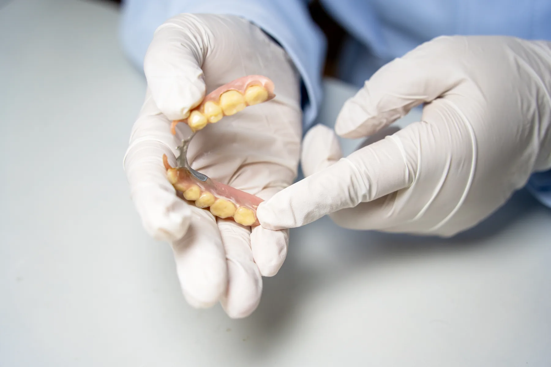 Dentist holding a removable partial denture for demonstration