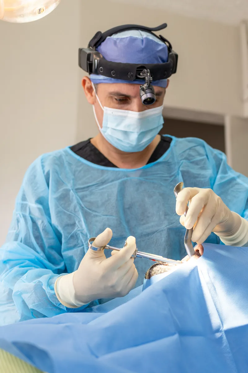 Dental surgeon performing a carefully controlled tooth extraction procedure