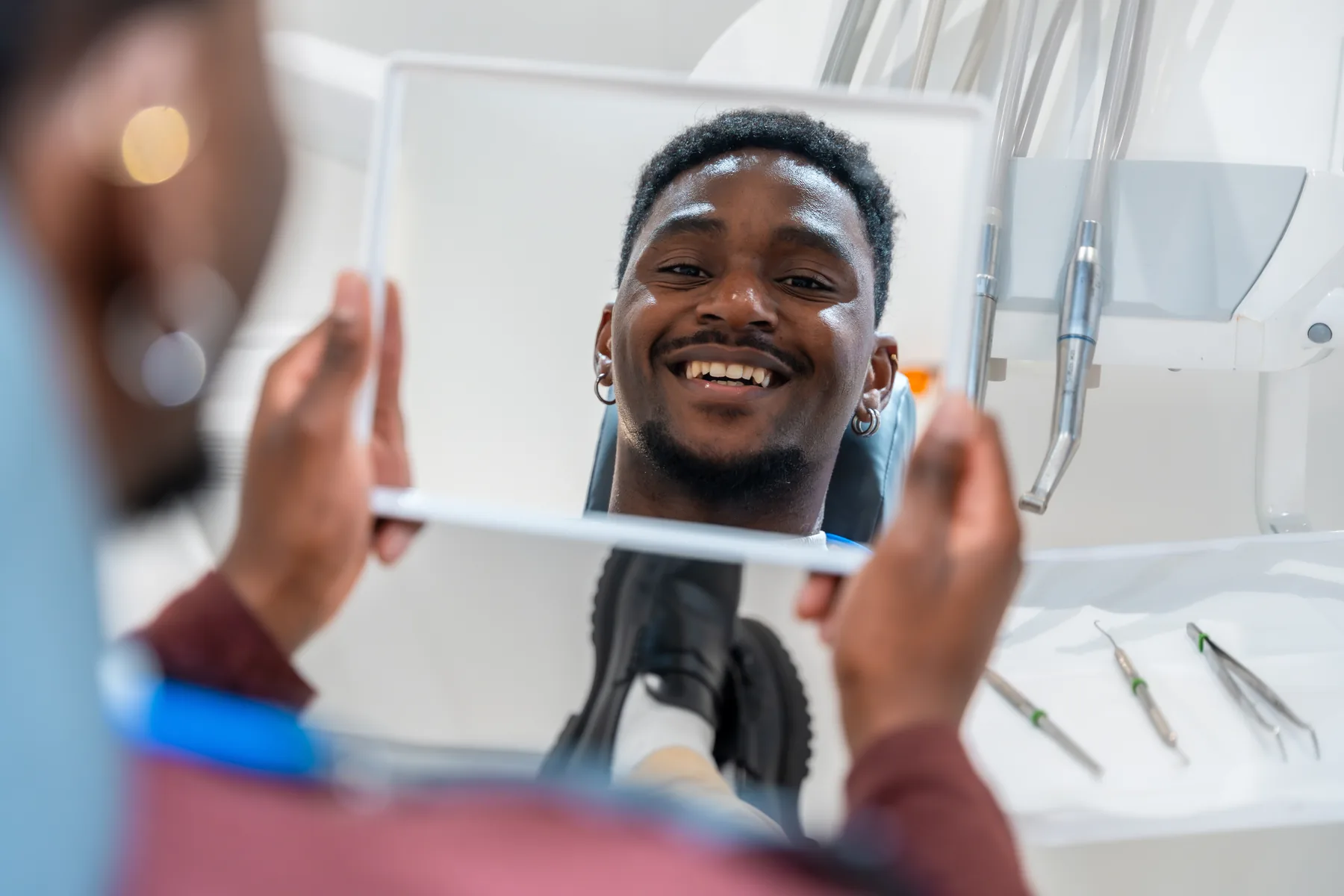 Patient viewing professional teeth whitening results in a mirror