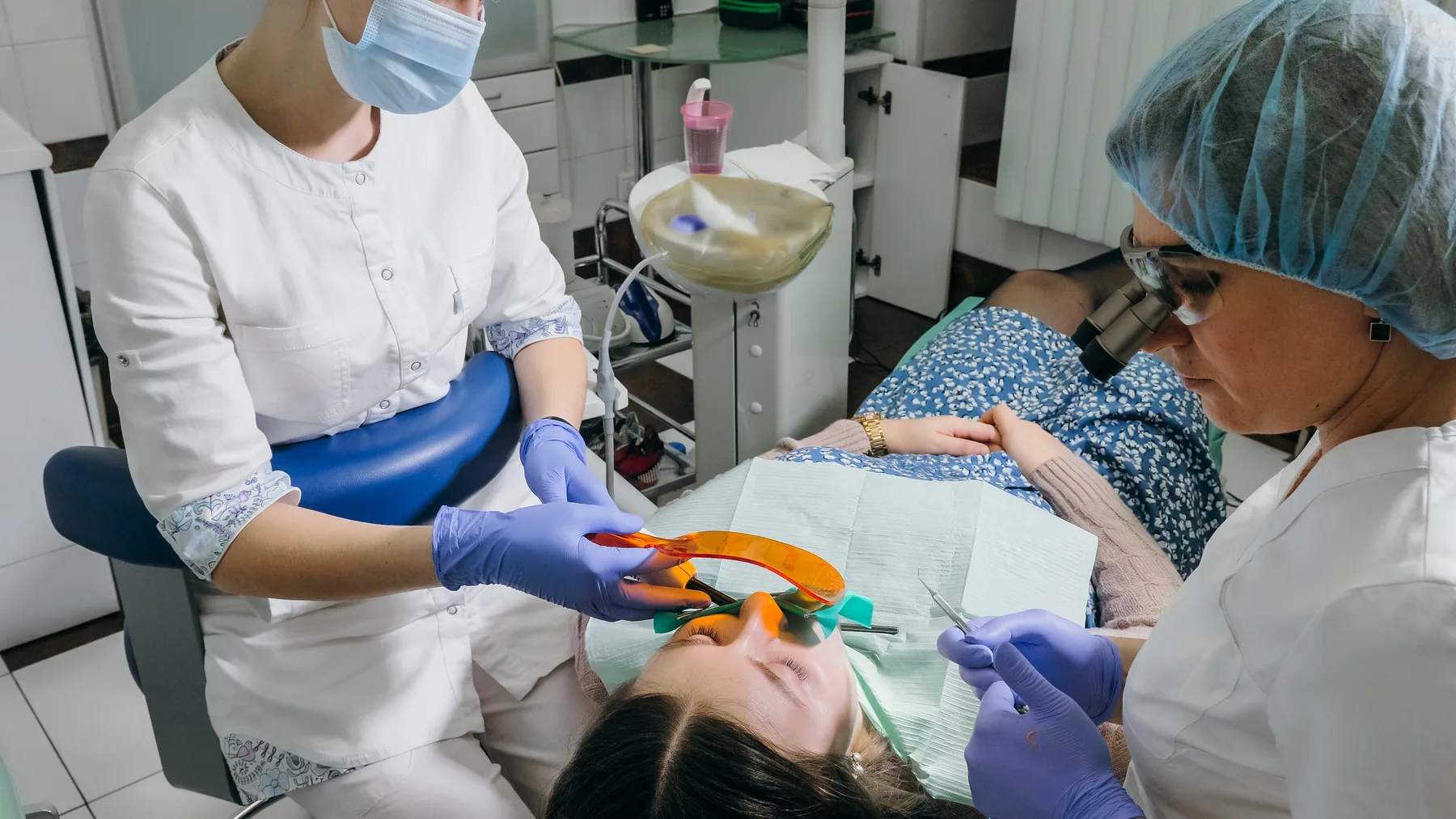 Dentist placing a tooth-colored composite filling with an assistant