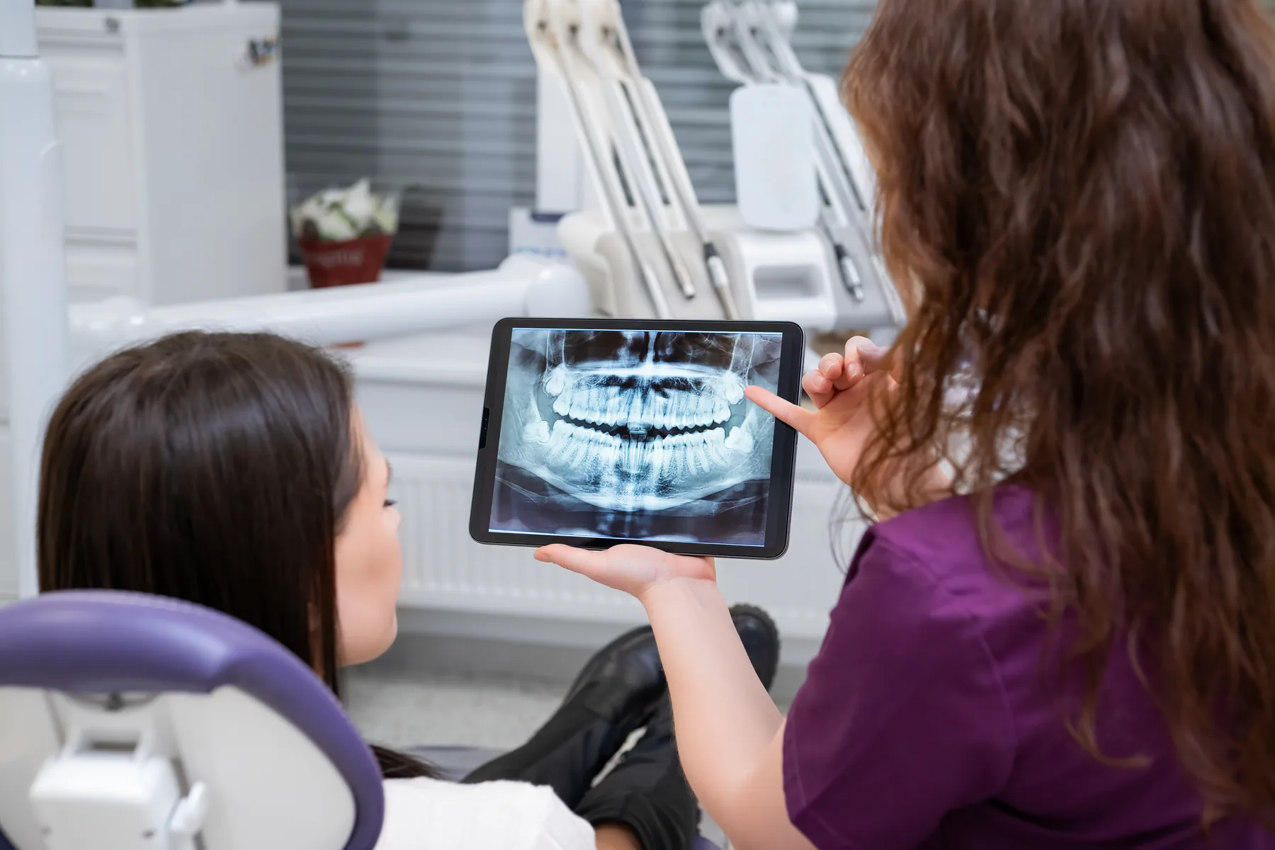 Dentist reviewing an x-ray and extraction treatment with a patient