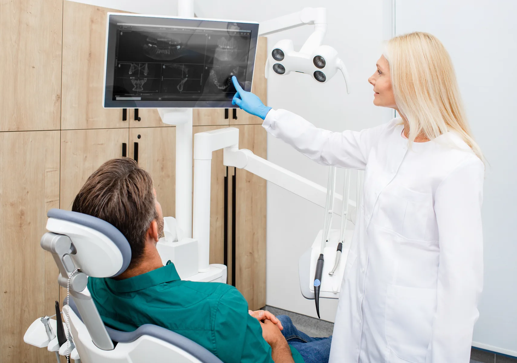 Dentist consulting with a patient experiencing wisdom tooth pain